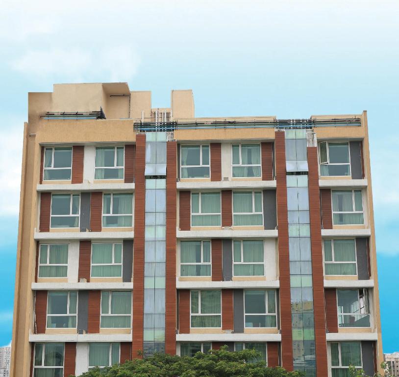 een hoog gebouw van rode baksteen met ramen bij The Byke Delotel in Mumbai