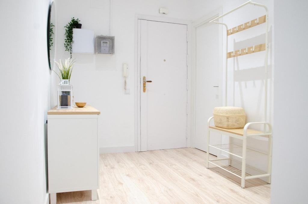 a white hallway with a white door and a chair at Apartamento NUEVO con encanto en SAGRADA FAMILIA in Barcelona