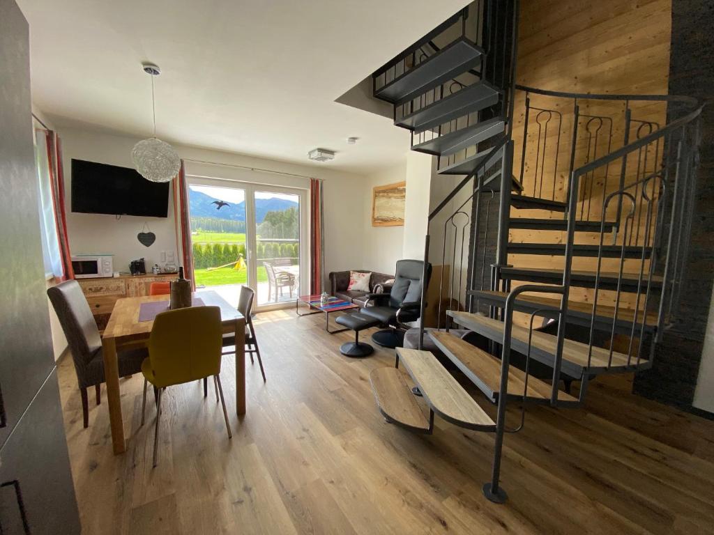a living room with a spiral staircase and a dining room at Alpenapartments Steiermark in Bad Mitterndorf