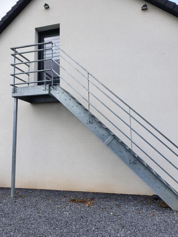 a metal staircase on the side of a building at Avocette in Yvrench