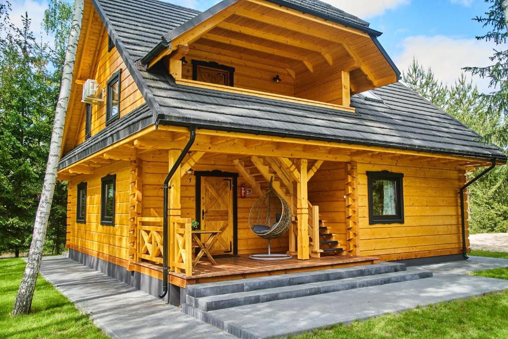 drewniany domek z werandą i tarasem w obiekcie Polana Świerkowa w Okunince