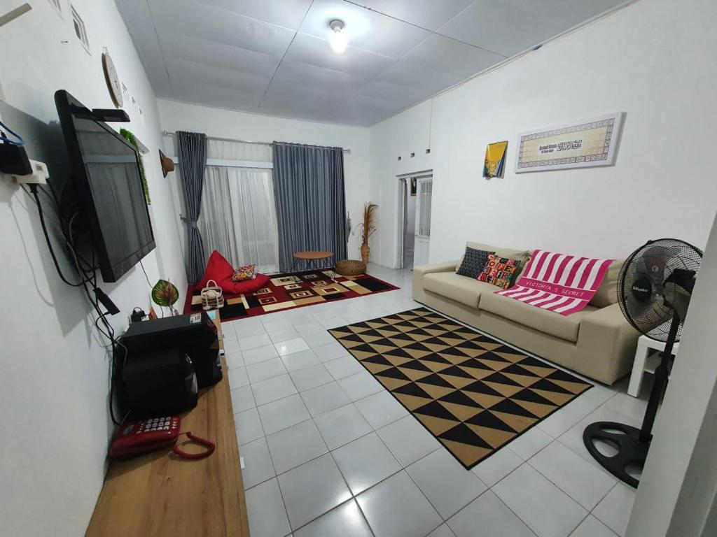 a living room with a couch and a tv at Stay@Pitaloka in Cirebon