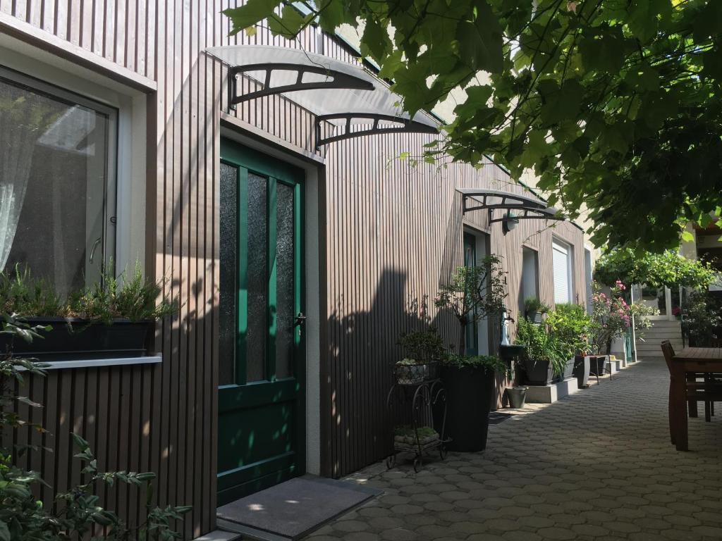 ein Gebäude mit grüner Tür und einigen Topfpflanzen in der Unterkunft Weingut Krikler in Weiden am See