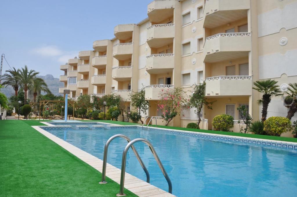 a swimming pool in front of a building at Apartamentos Las Rosas in Denia