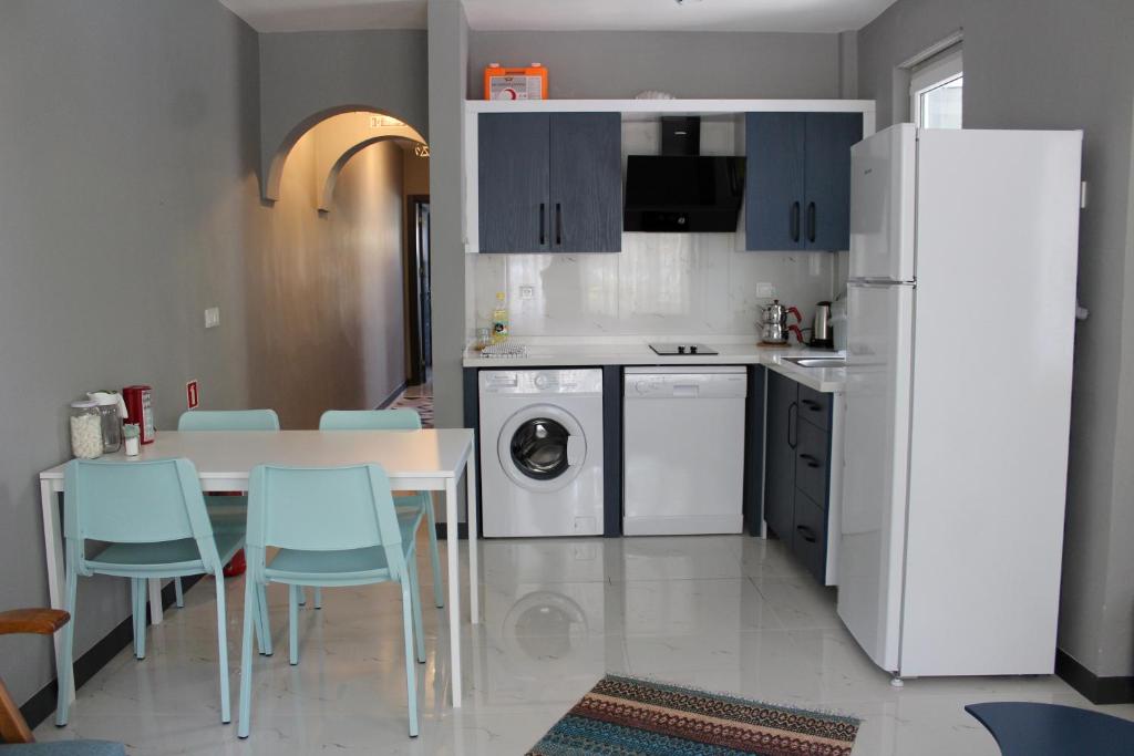 a kitchen with a table and a white refrigerator at Alpat Homes in Kemer