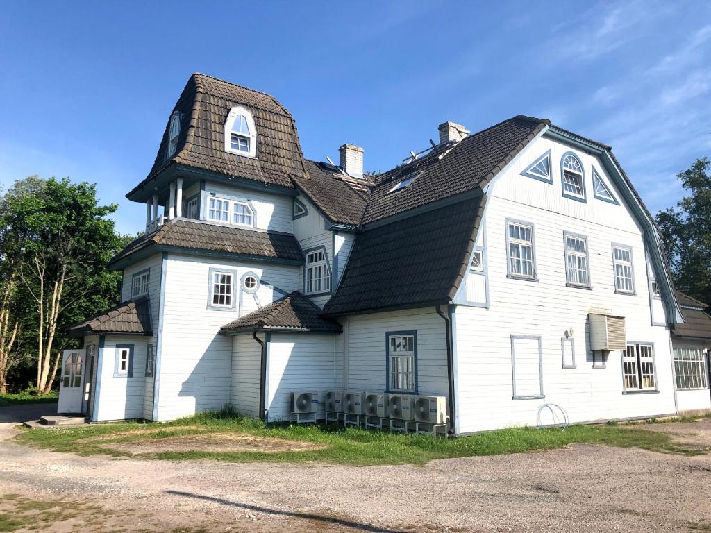 duży biały dom z czarnym dachem w obiekcie Captains House - Kaptenimaja - Officers deck w mieście Kärdla