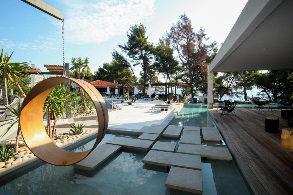 a swimming pool with a swing and a swimming pool at Nostos Hotel in Afitos