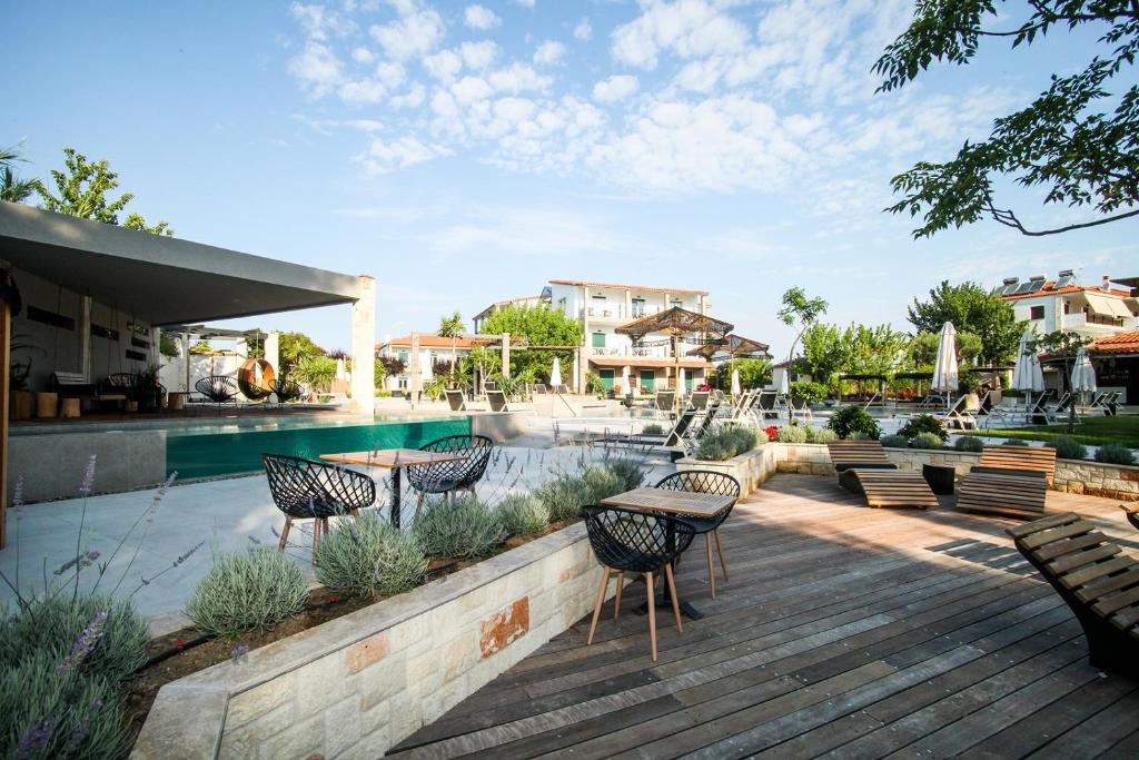 a patio with chairs and a swimming pool at Nostos Hotel in Afitos