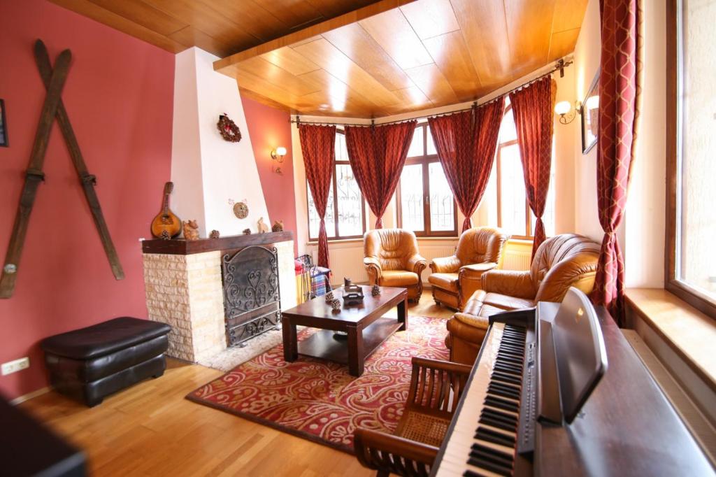 un salon avec une cheminée et un piano dans l&#39;établissement Transylvanian Villa, à Predeal