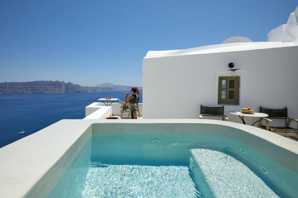 una piscina sul lato di una casa di Rhenia's Suites a Oia