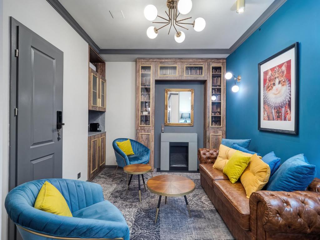 ein Wohnzimmer mit blauen Wänden, einem Sofa und Stühlen in der Unterkunft A22 Boutique Suites in Budapest