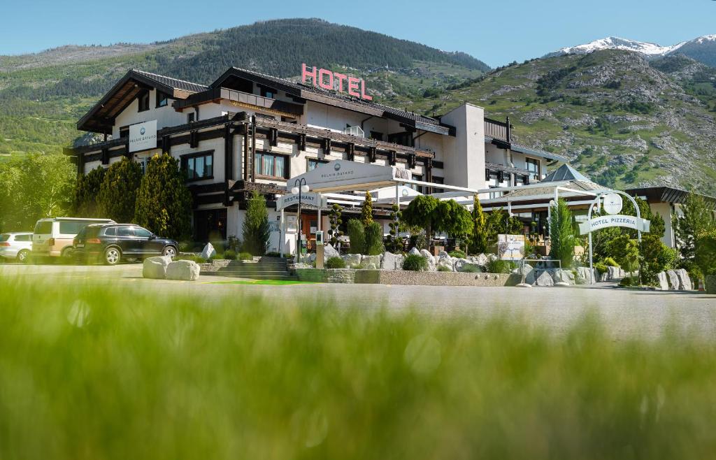 a hotel with a building with mountains in the background at Relais Bayard in Susten