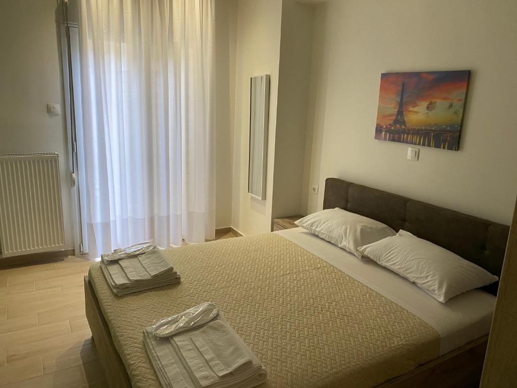 una camera da letto con un letto con due asciugamani sopra di Great Alexander street, Larisa a Larisa