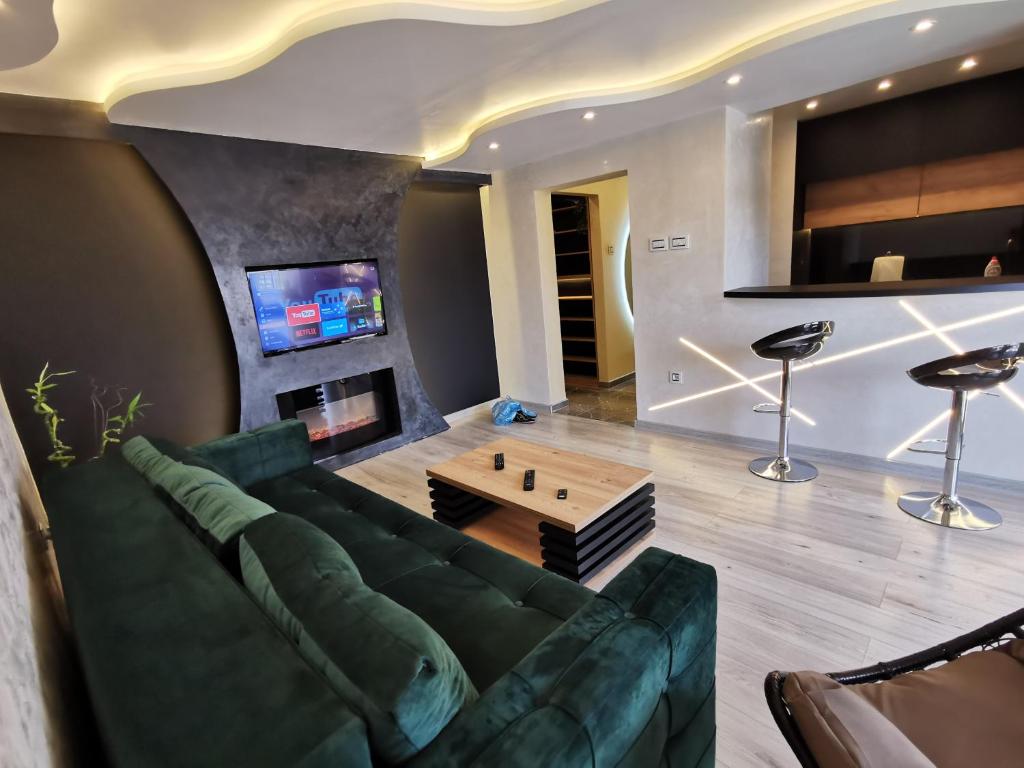 sala de estar con sofá verde y mesa en Brend new luxurious apartment in downtown with free parking en Novi Sad