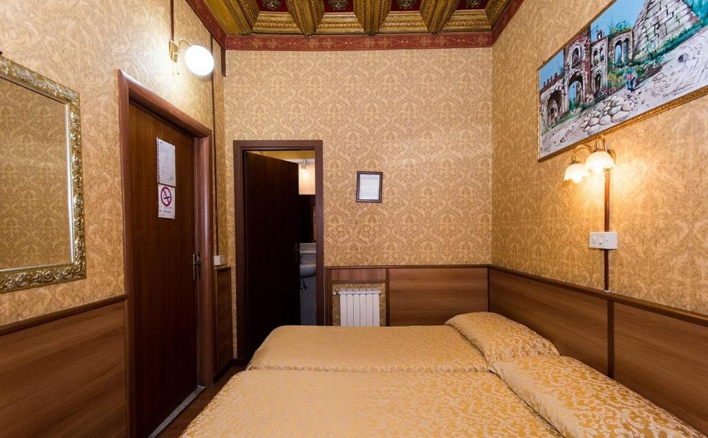 a small bedroom with two beds in it at Hotel Artromano in Rome