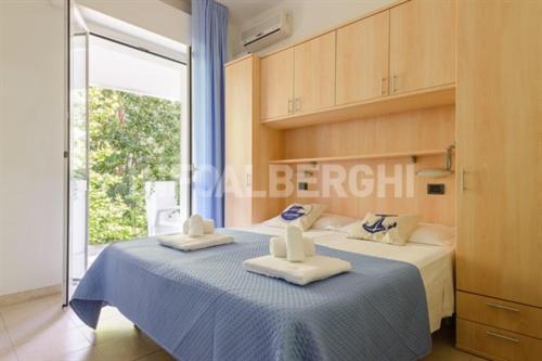 ein Schlafzimmer mit einem Bett mit zwei Handtüchern darauf in der Unterkunft Hotel Nautilus in Bellaria-Igea Marina