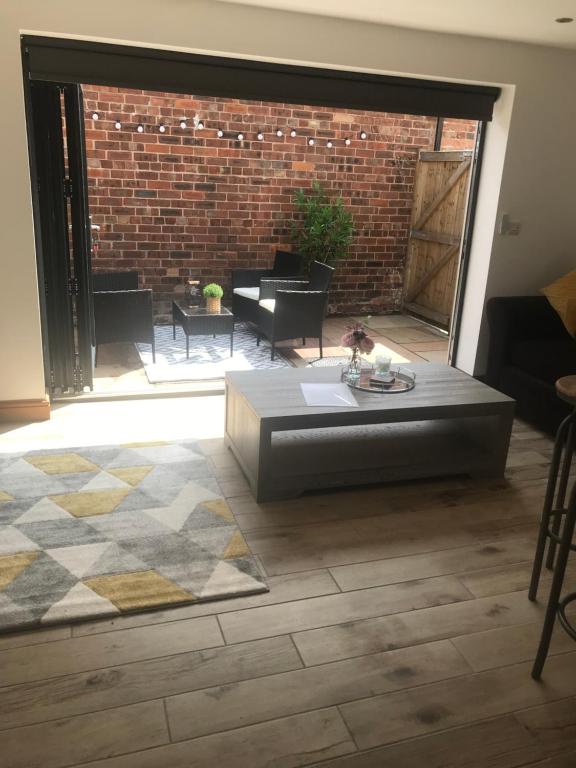 a living room with a coffee table and a brick wall at No 6 Elizabeth Street in Congleton