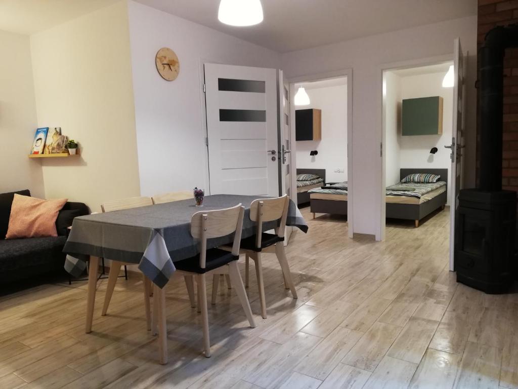 - une salle à manger et un salon avec une table et des chaises dans l'établissement Domek nad jeziorem, à Kamienica Królewska
