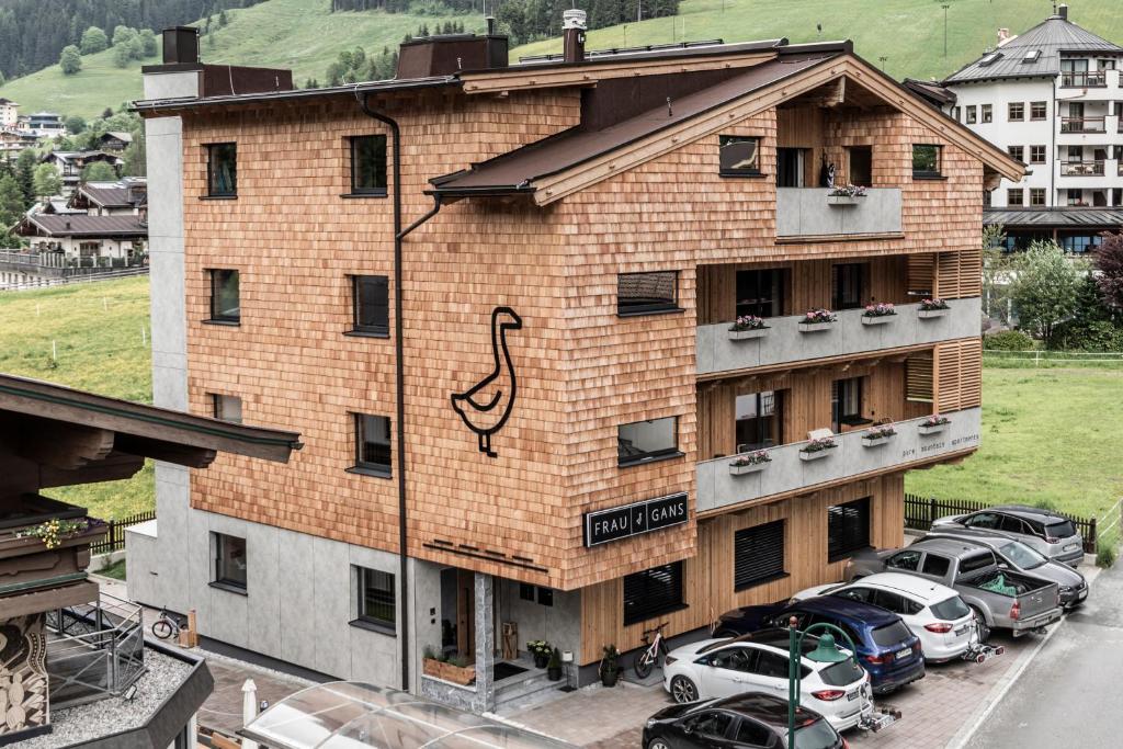 a building with cars parked in front of it at FRAU GANS - pure mountain apartments in Saalbach-Hinterglemm