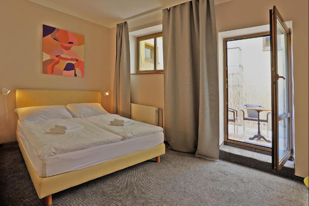 a bedroom with a bed and a large window at Hotel Pilgrim in Karlovy Vary