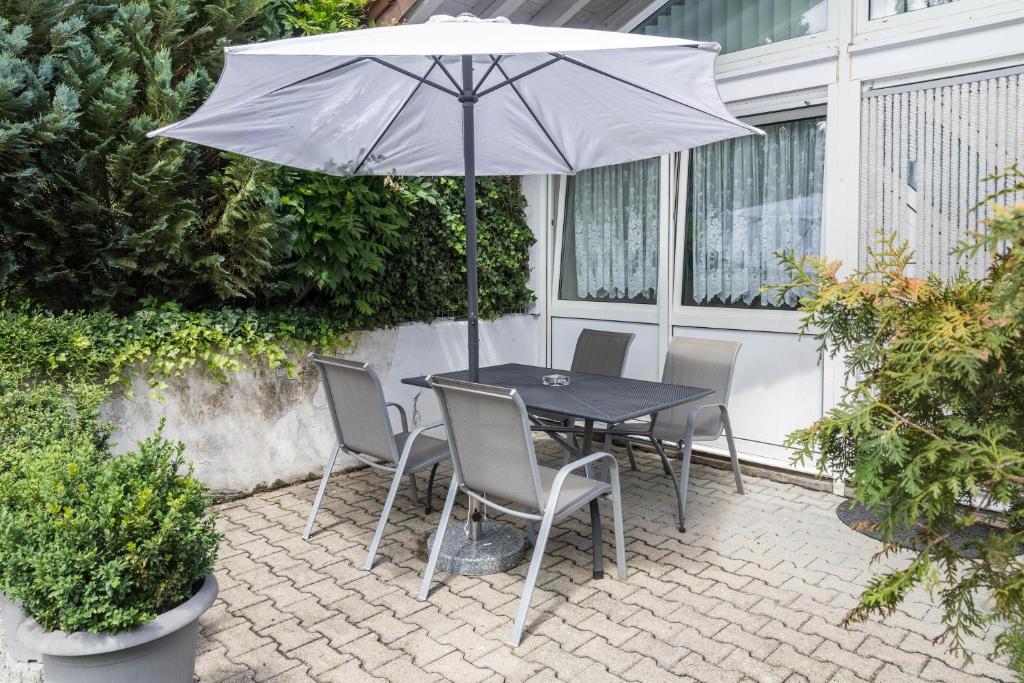 a table and chairs with an umbrella on a patio at Fewo Eg Links - Hunde erlaubt in Oberteuringen