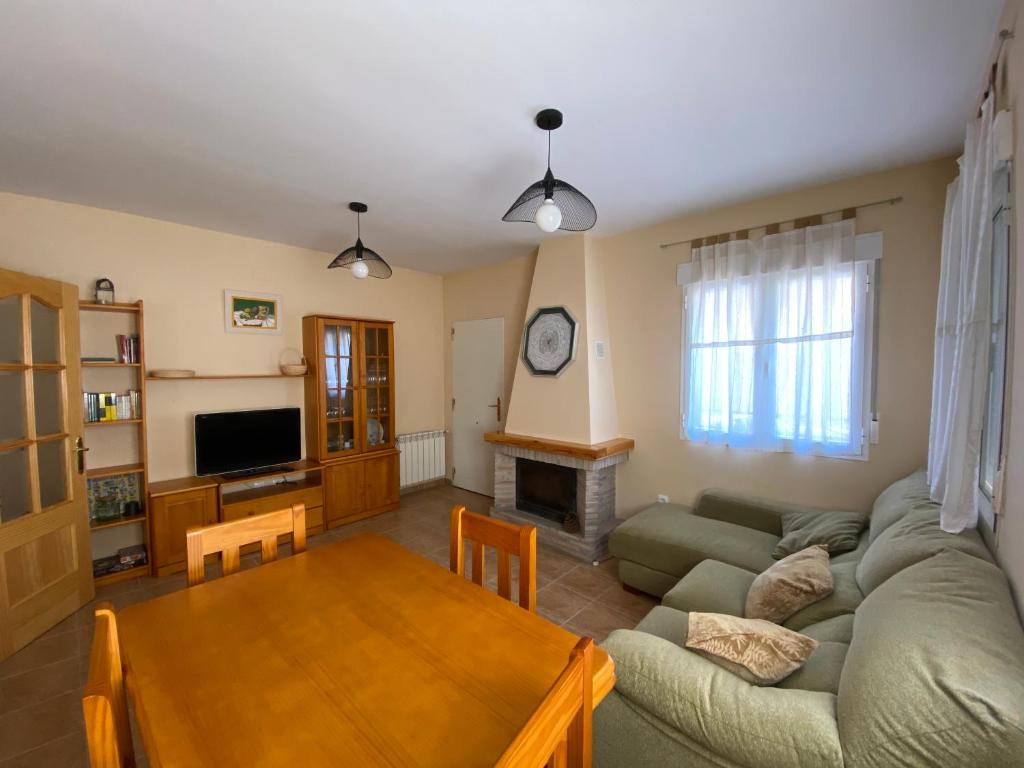 sala de estar con sofá y mesa en El Rincón de Dorotea - Casa rural, en Villalba de la Sierra