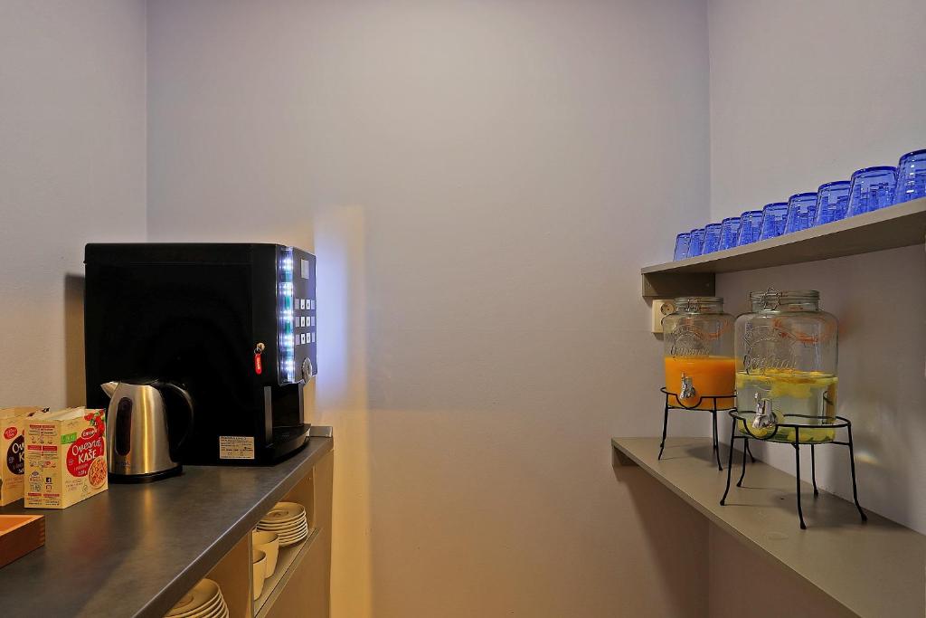 a kitchen with a coffee maker and a microwave at Hotel Pilgrim in Karlovy Vary