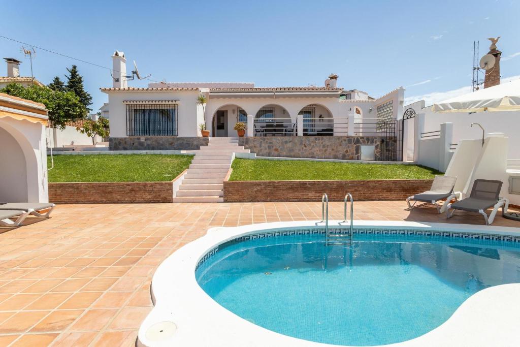 una piscina frente a una casa en Casa Vistas Axarquia, en Vélez-Málaga