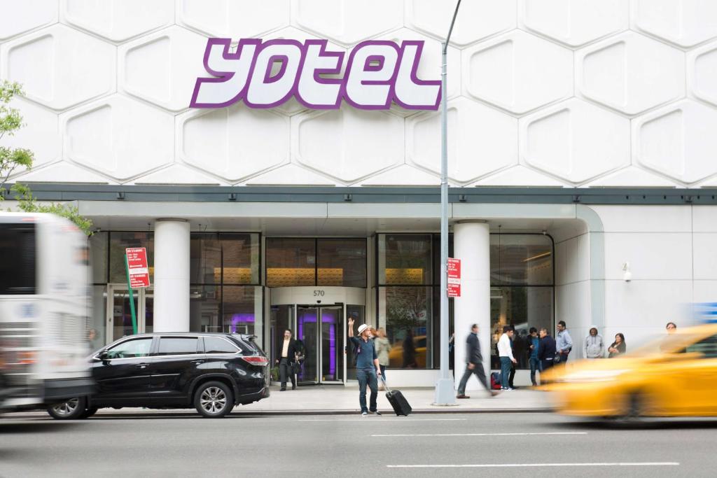 Um homem está a andar em frente a uma loja. em YOTEL New York Times Square em Nova York