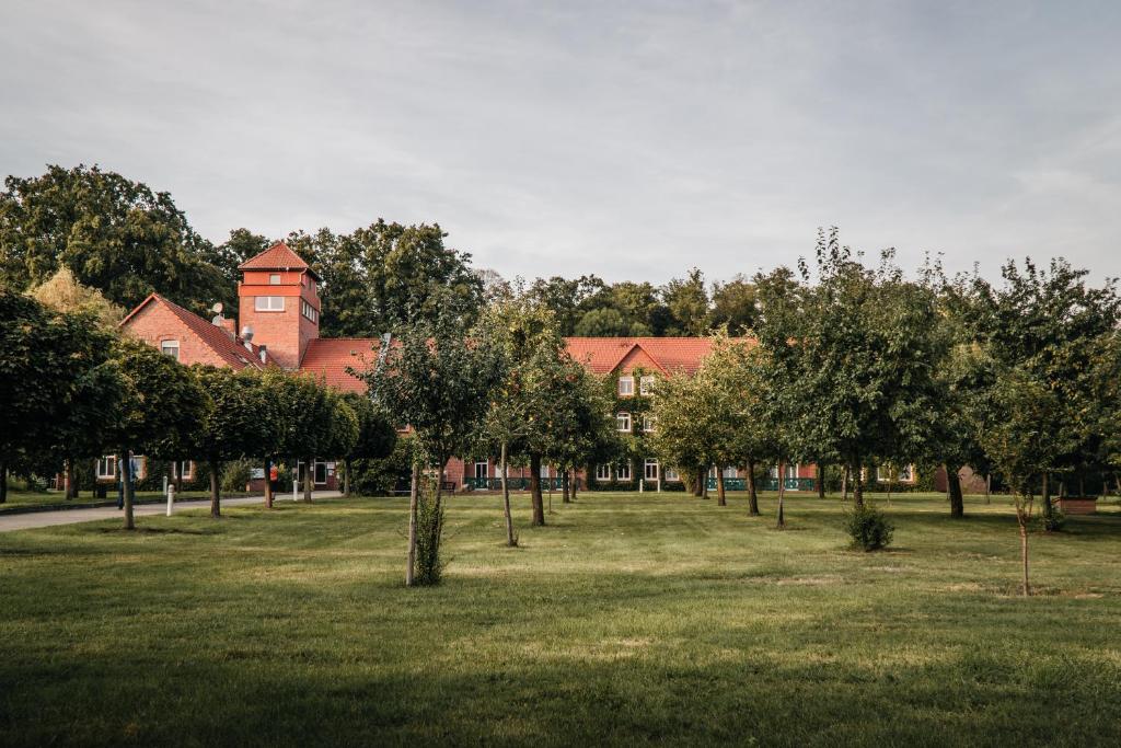 a field with trees in front of a building at Waldhotel Eiche in Burg