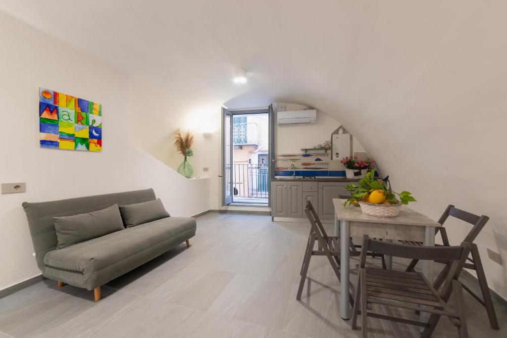 ein Wohnzimmer mit einem Sofa und einem Tisch in der Unterkunft Centro Storico Apartment in Procida