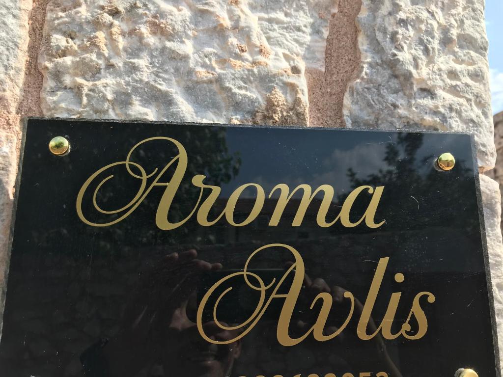 Znak aounditzolis na kamiennej ścianie w obiekcie Aroma Avlis Apartments w mieście Areopolis
