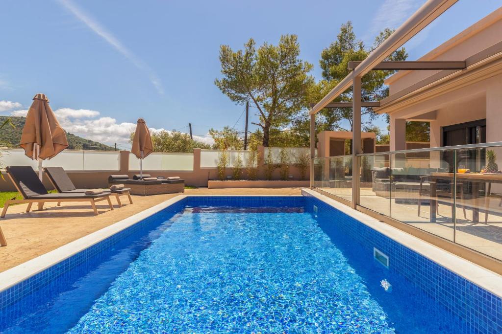 a swimming pool in the backyard of a house at Amelia Residence in Tragaki