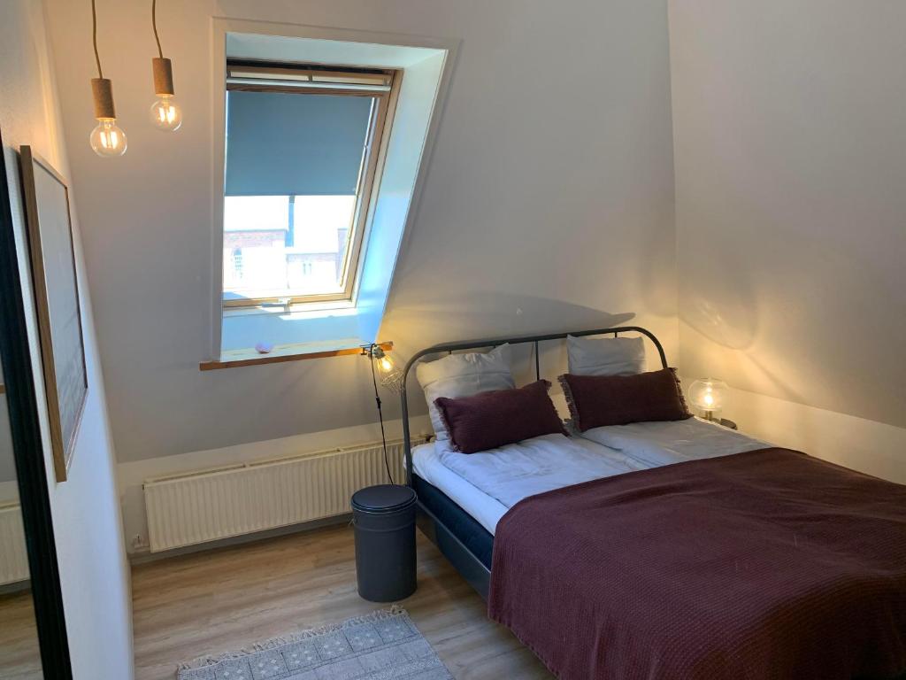 - une petite chambre avec un lit et une fenêtre dans l'établissement 4 personers ferielejlighed, à Løkken
