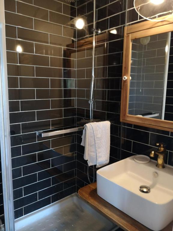 a black tiled bathroom with a sink and a mirror at Studio with large balcony and nice view by Weekome in Vallauris