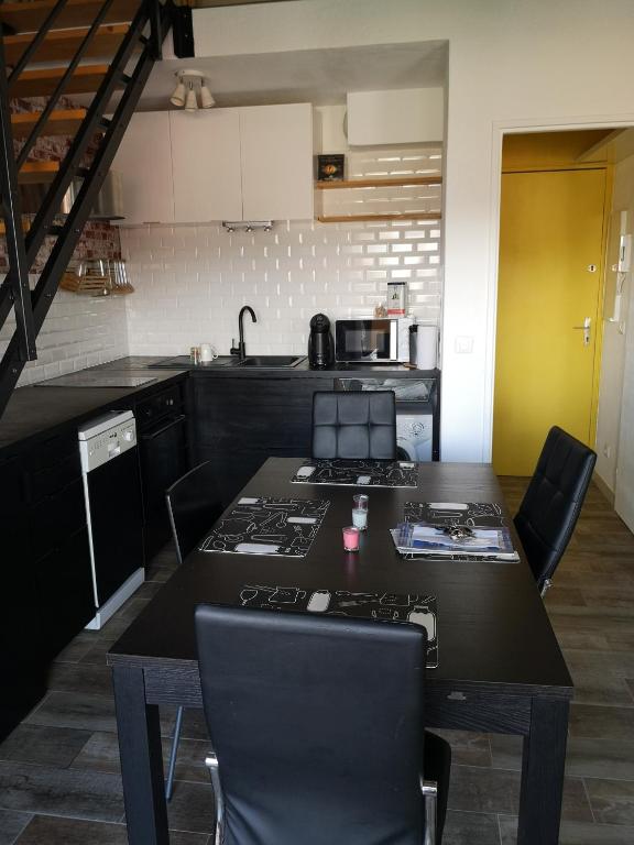 a kitchen with a table with chairs and a stove at Studio with large balcony and nice view by Weekome in Vallauris