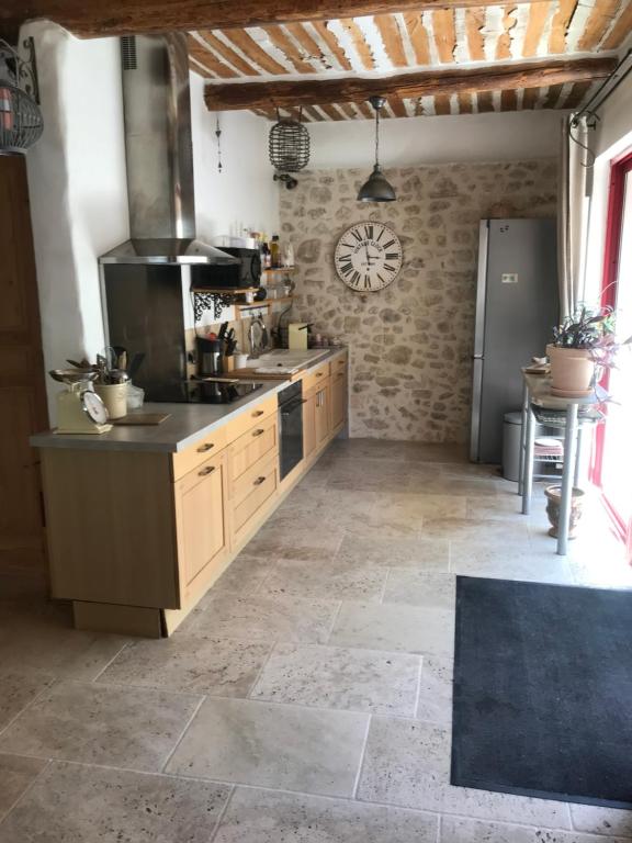 a large kitchen with a stove and a sink at La Charmeuse in Céreste