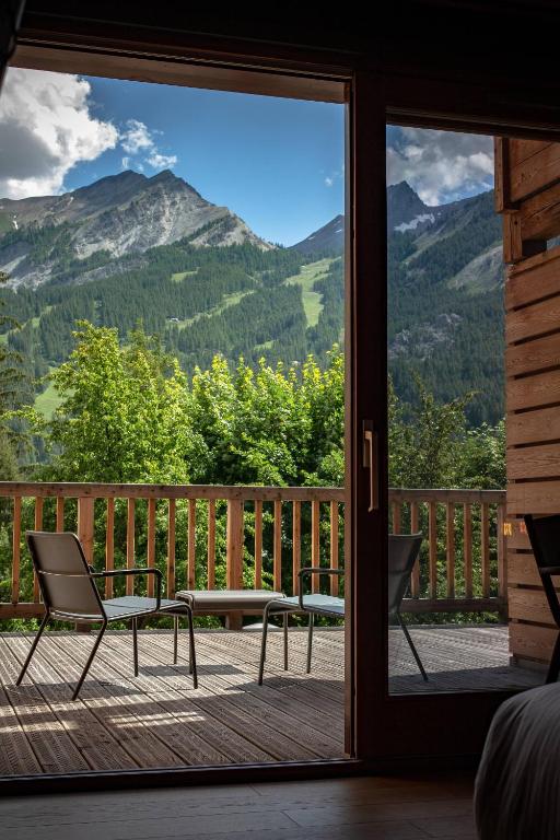 a sliding glass door with a view of mountains at Hôtel Restaurant Le Monêtier in Le Monêtier-les-Bains