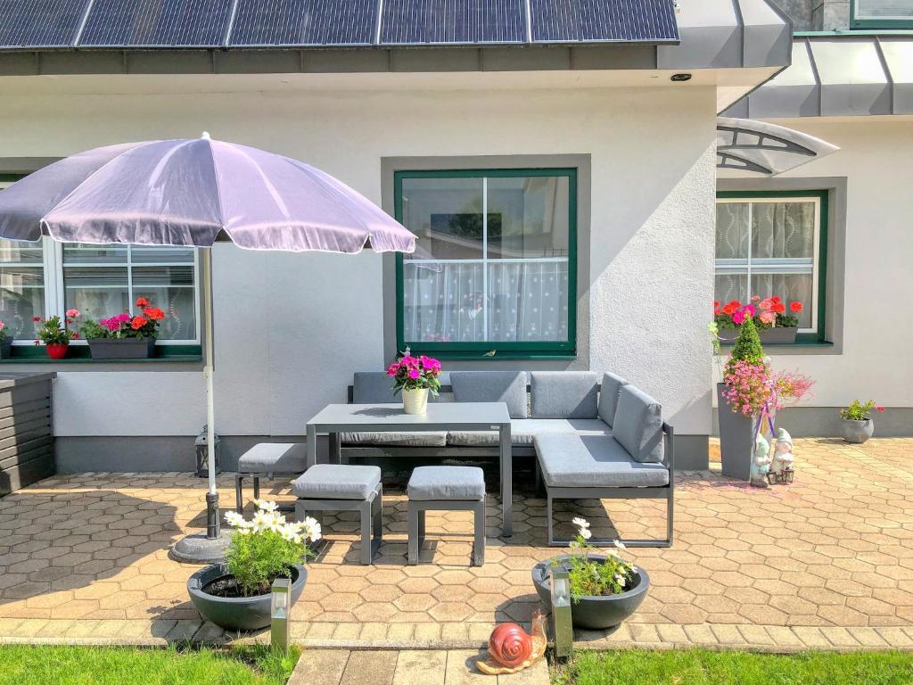 a patio with a table and an umbrella at Apartment Birke 2 - by Alpen Apartments in Bad Gastein