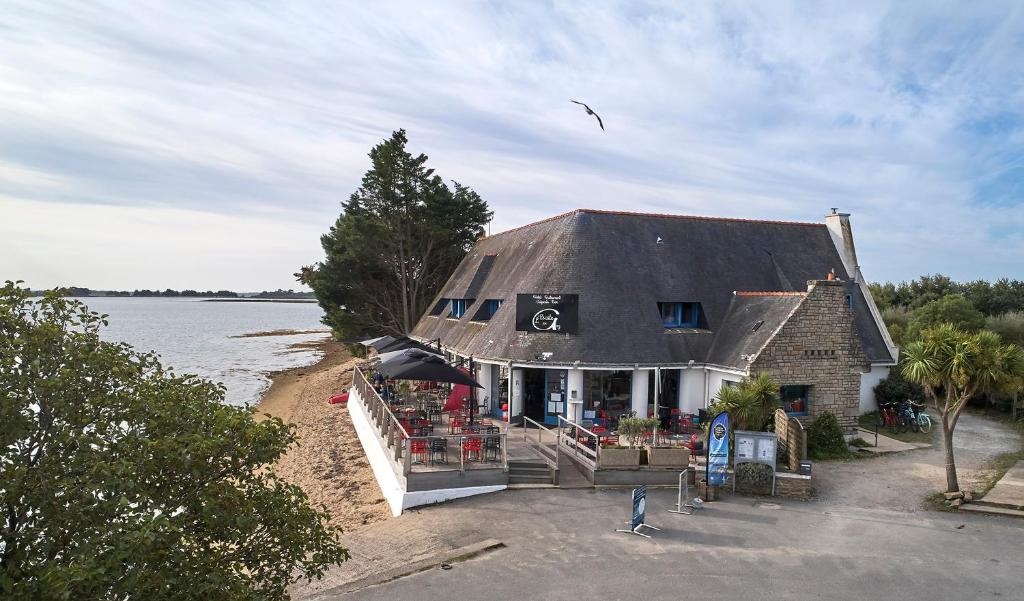 un bâtiment sur la rive d'une masse d'eau dans l'établissement Hôtel Restaurant L'Escale d'en Arz, à l'Île-d'Arz