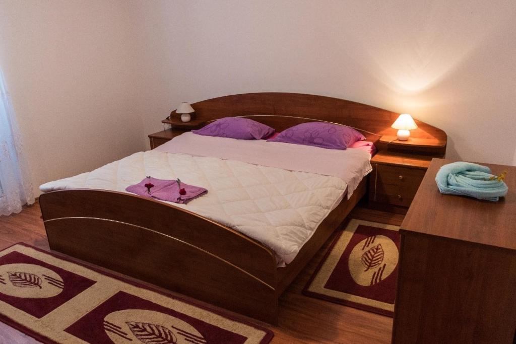 ein Schlafzimmer mit einem großen Bett mit lila Kissen in der Unterkunft Apartment in Mundanije with balcony, air conditioning, WiFi (4912-1) in Mundanije