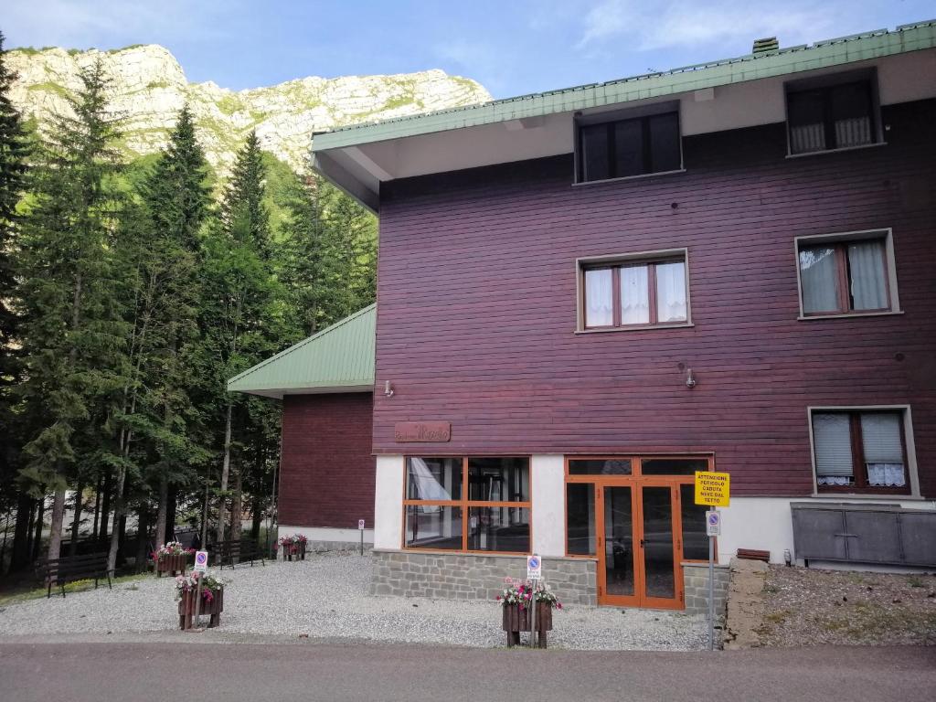 un gran edificio púrpura con montañas en el fondo en Val di Luce Home, en Abetone