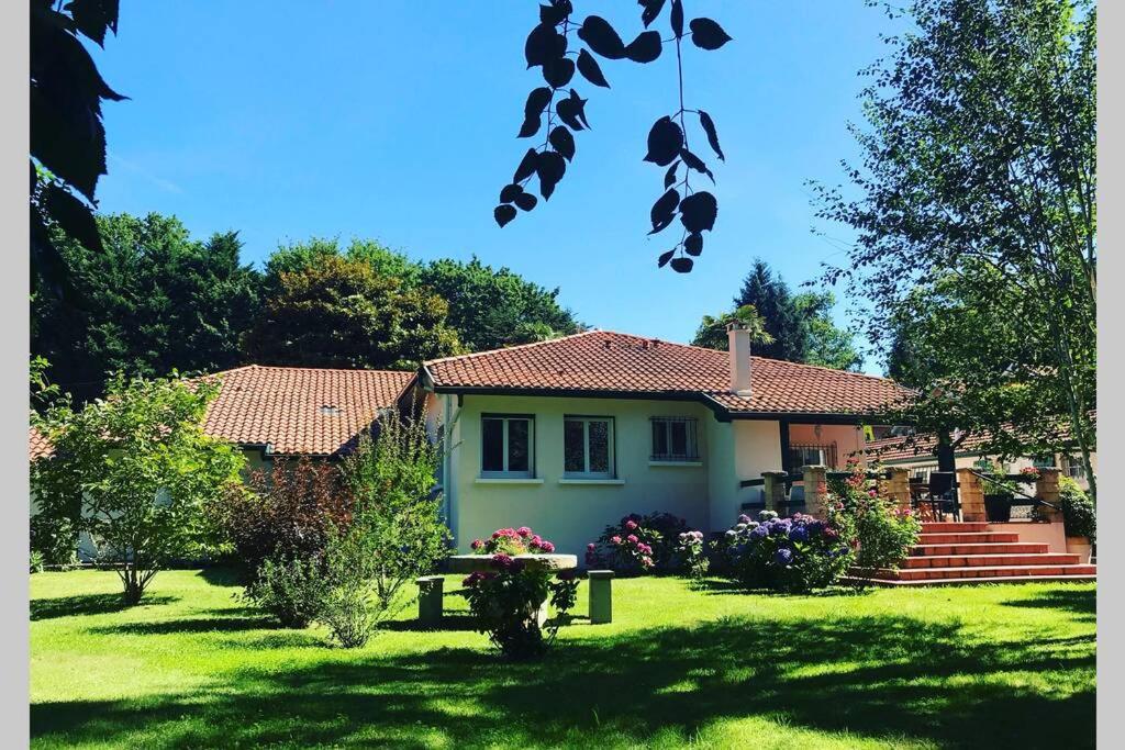 a house in a yard with a green yard sidx sidx sidx at Villa de charme parc fleuri, arboré et piscine à BIARRITZ in Biarritz