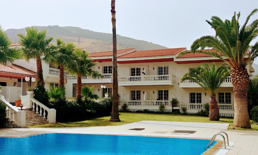 een huis met een zwembad en palmbomen bij Villa Olympia in Galaxidhion