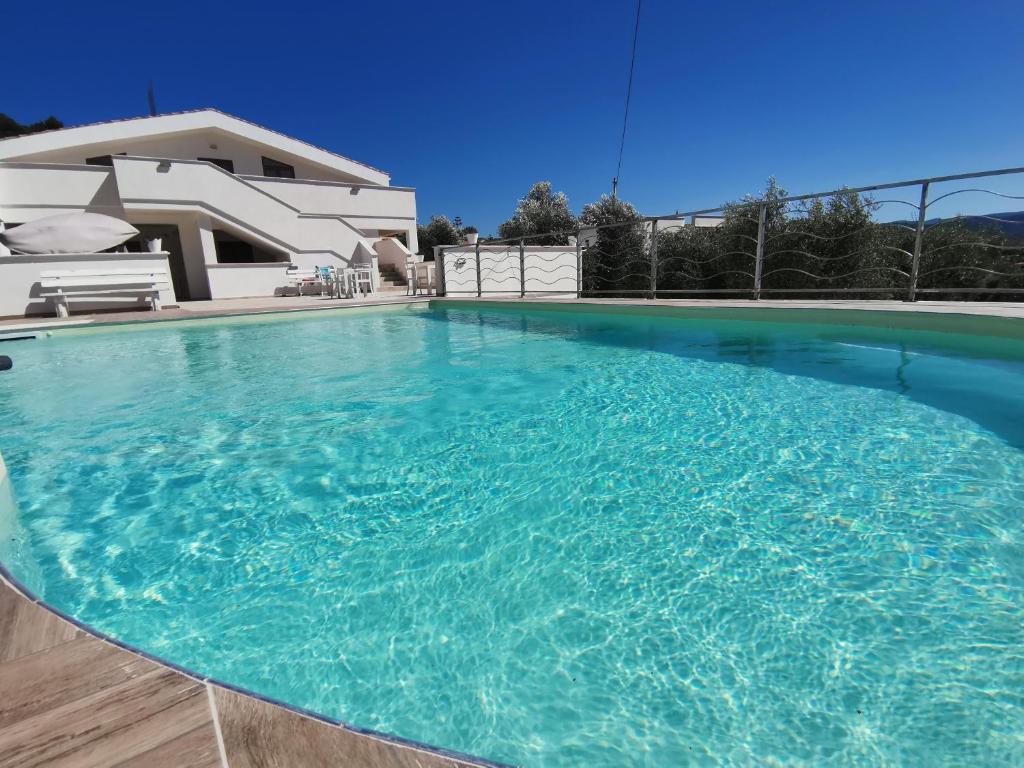 uma piscina com água azul em frente a uma casa em La Duchessa e Il Contadino em Vieste
