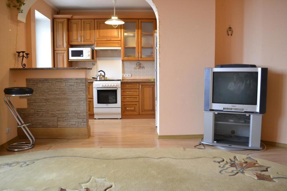 sala de estar con TV y cocina en Studio Apartments, en Kamianets-Podilskyi