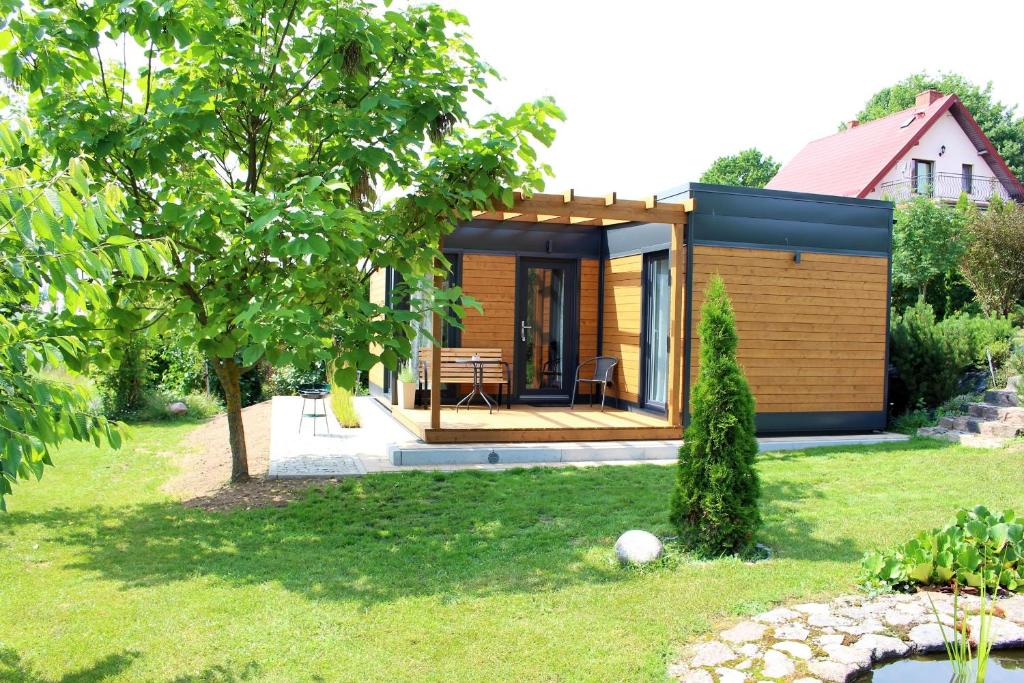 una casa pequeña con terraza en un patio en Domek Nad Zalewem, en Gołdap