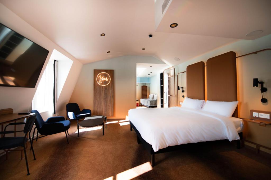a bedroom with a bed and a desk and chairs at YOU Are Deauville in Deauville