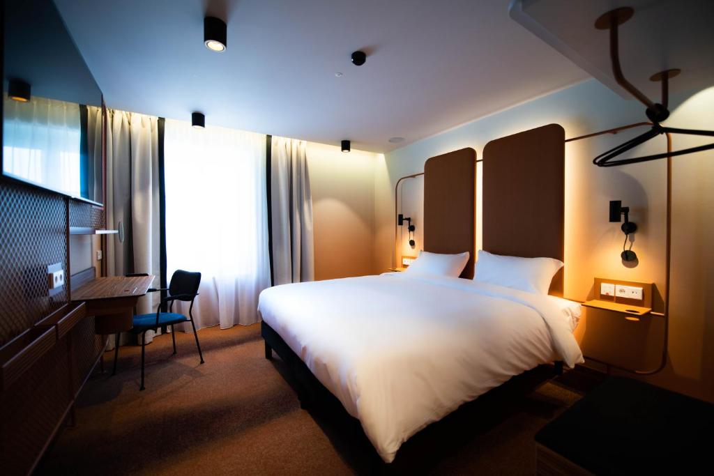 a hotel room with a large bed and a desk at YOU Are Deauville in Deauville