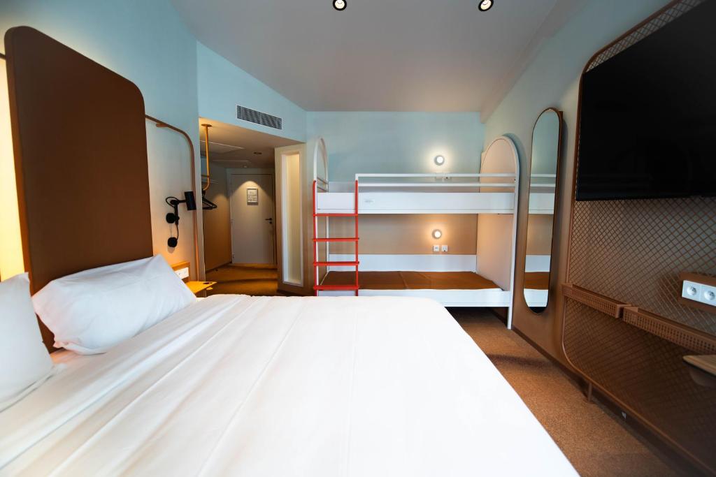 a bedroom with two bunk beds and a flat screen tv at YOU Are Deauville in Deauville